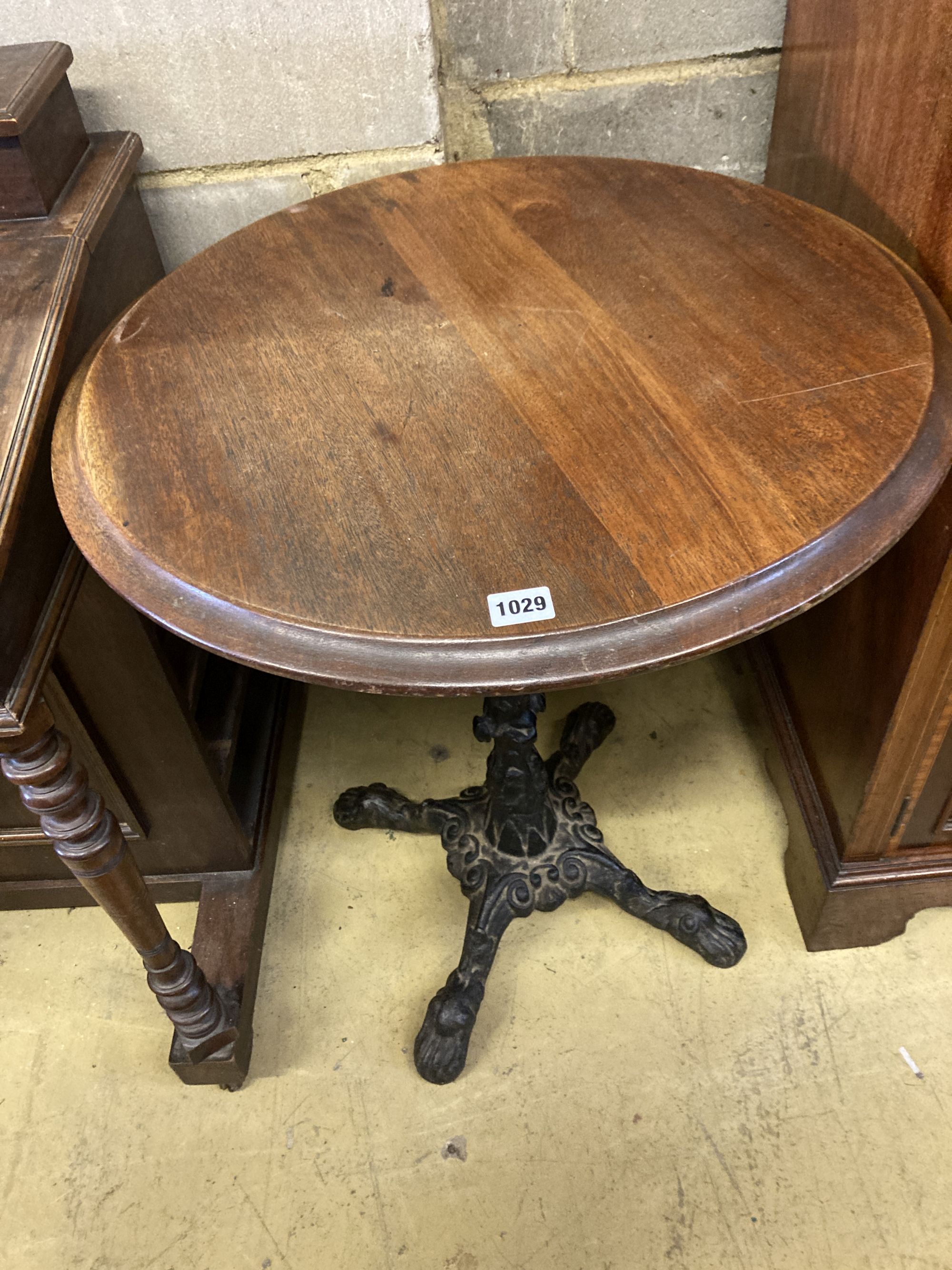 A Victorian style cast iron circular mahogany topped table, 58cm diameter, height 72cm